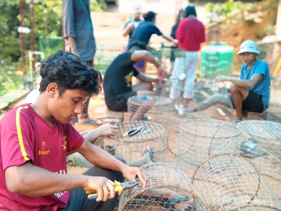 Members of Phevima Eco Club making waste bins out of mesh wire.